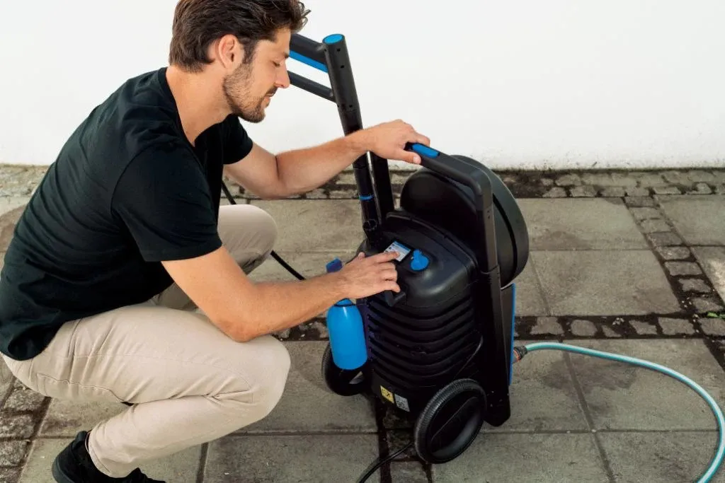 En blå vegg som er full av mye forskjellig tilbehør til Nilfisk høytrykksvaskere.